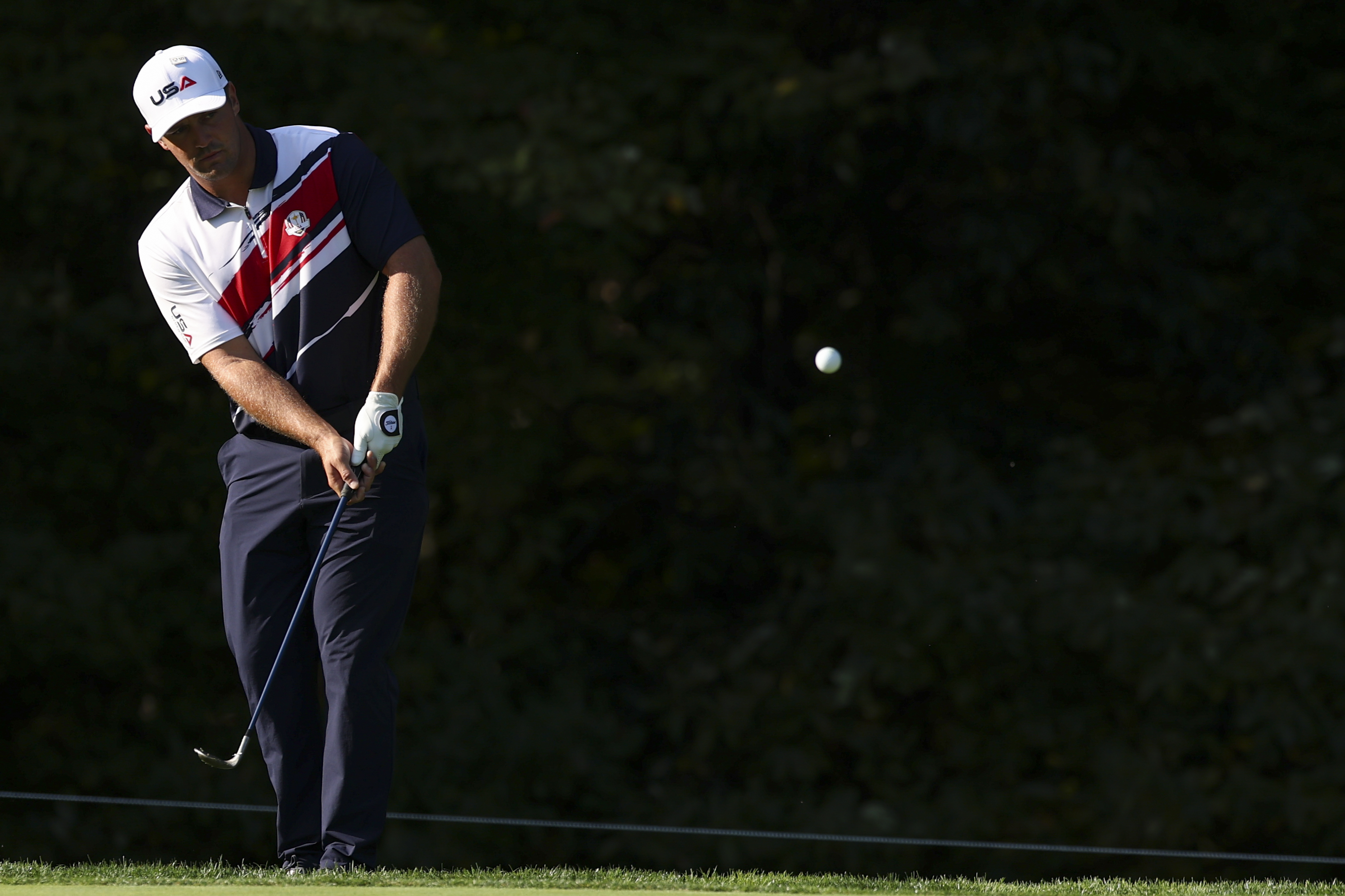 Bryson DeChambeau hits a wedge shot from the edge of the green