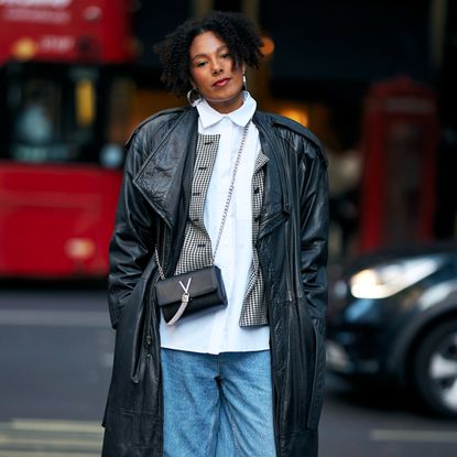 woman wearing a leather jacket, a white button-down, and jeans