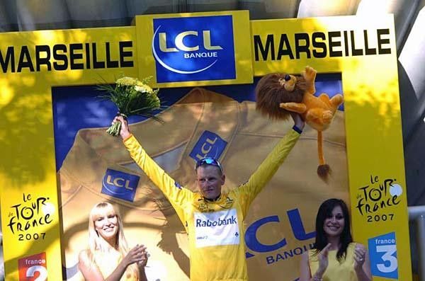Michael Rasmussen celebrates another bouquet of flowers, along with lion and, last but not least, the yellow jersey.