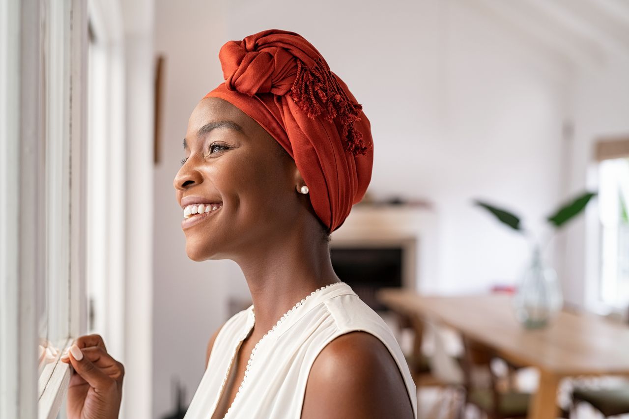 a woman in a head turban showing bowel cancer symptoms