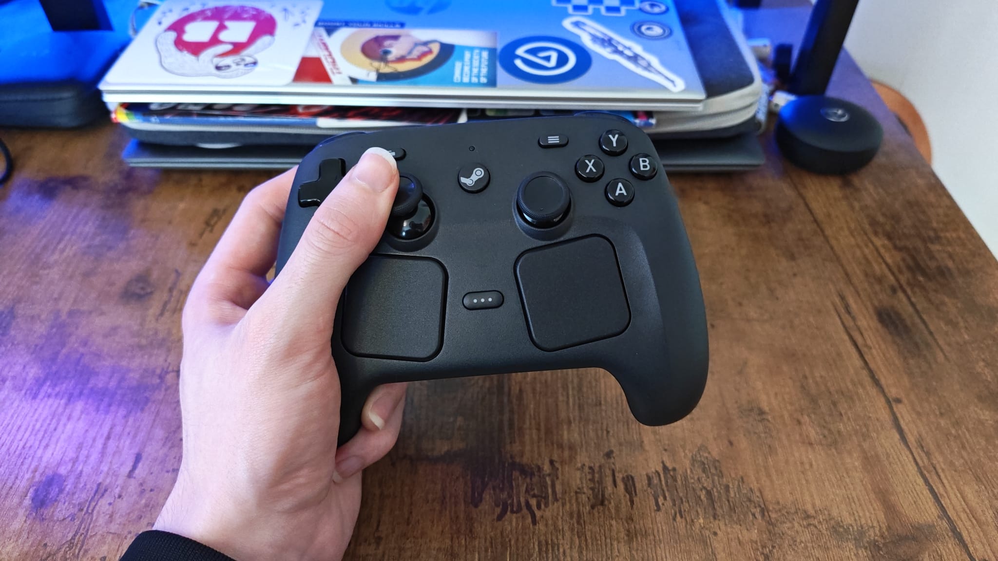 A reviewer holding the Steam Controller