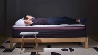 A person lying on their back on the Helix Dusk Luxe mattress