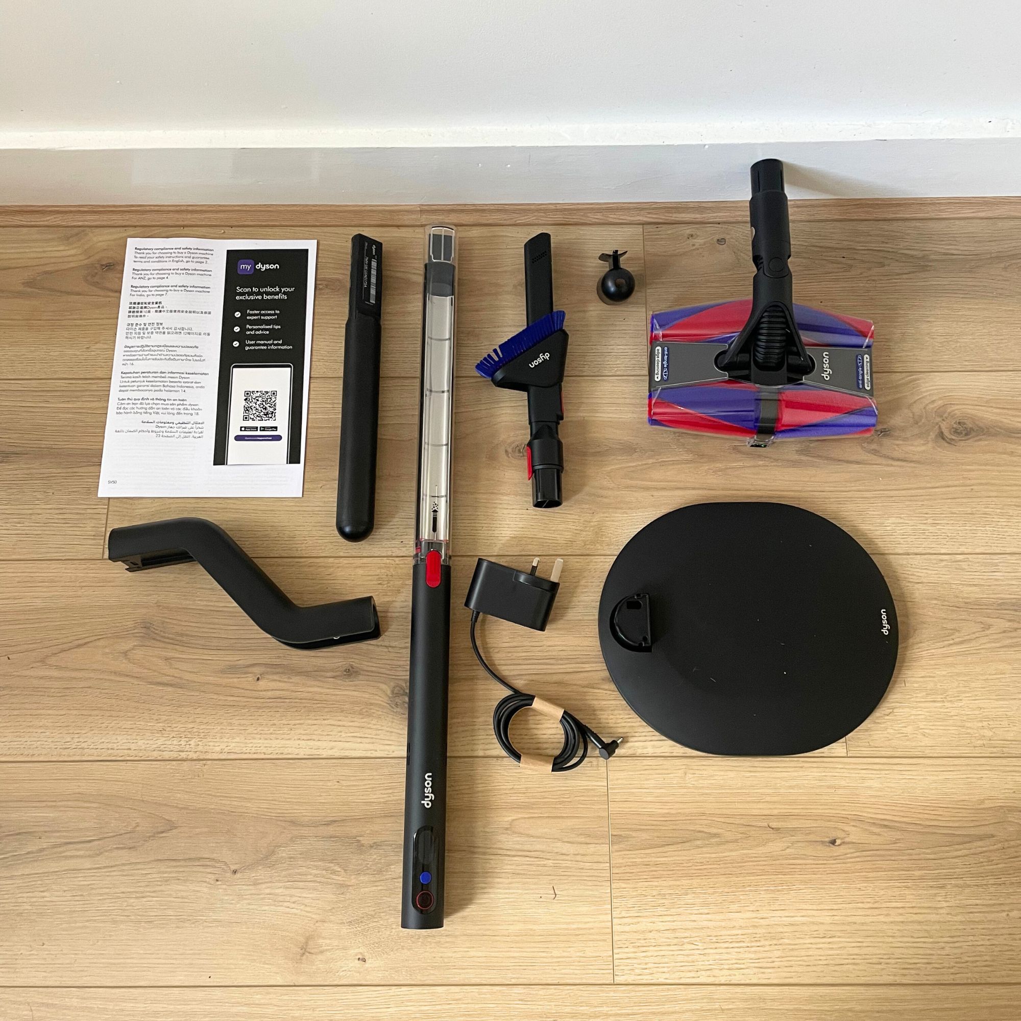 Dyson PencilVac components laid out on wood-effect flooring