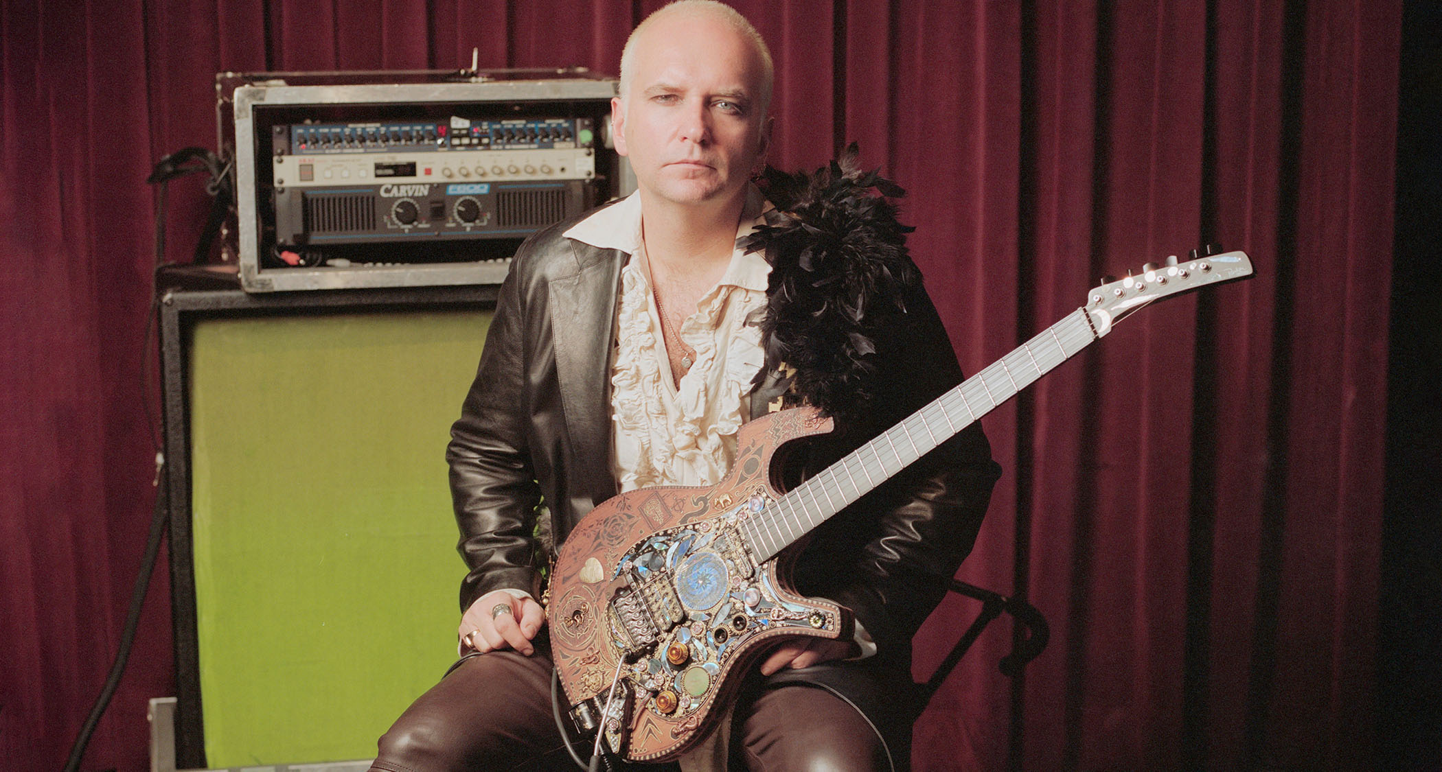 Reeves Gabrels sits with his rig and his custom steam-punk Parker Fly electric guitar.
