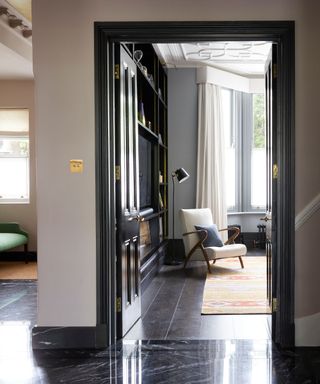 Black framed door, black floor, white chair