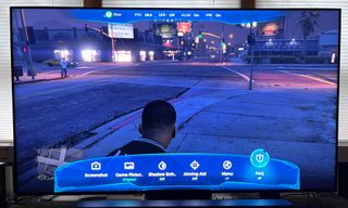 TCL QM8 showing game menu screen overlay with GTA 5 in background