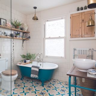 Bathroom with blue bath and brass overhead lighting