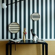 room with black wooden table and black and white patterned wallpaper