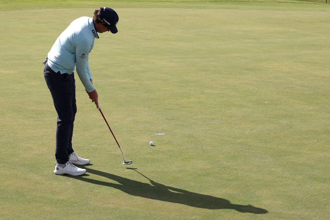 Adam Schenk hits a putt
