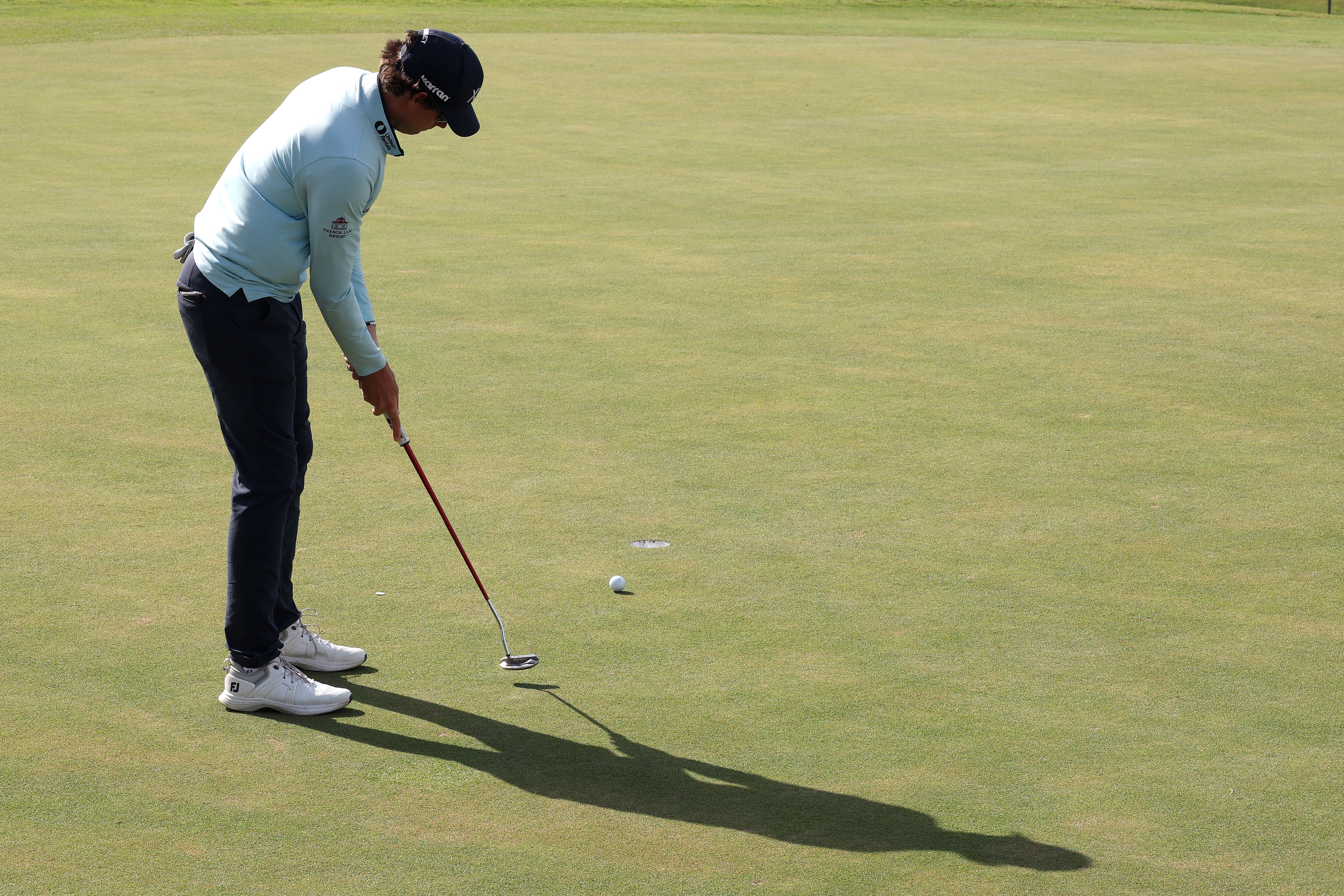 Adam Schenk hits a putt