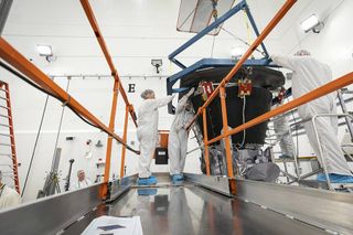 Parker Solar Probe's heat shield, called the Thermal Protection System, is lifted and realigned with the spacecraft's truss as engineers from the Johns Hopkins Applied Physics Lab prepare to install the 8-foot-diameter heat shield on June 27, 2018.