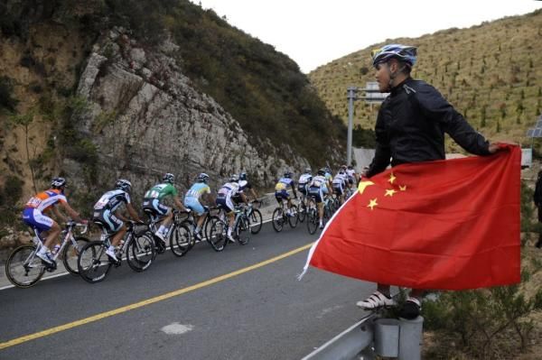A Chinese fan cheers on the riders