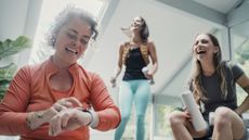 Three women in activewear laughing