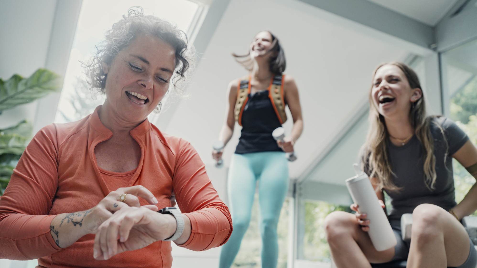Three women in activewear laughing
