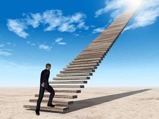 Man walking up staircase to the sky