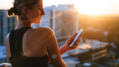 supersapiens-blood-glucose-monitoring-woman-wears-patch-and-looks-at-phone