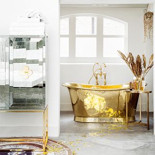 white bathroom with golden bathtub