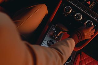 Genesis G70 car, interior image showing driver’s hands adjusting controls