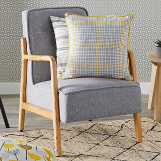 room with wallpaper on wall and grey chair with cushions