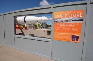 Plexiglas windows cut into the construction walls gives guests at NASA’s Kennedy Space Center Visitor Complex a view of the work restoring the last remaining, launch-configured Saturn IB rocket.
