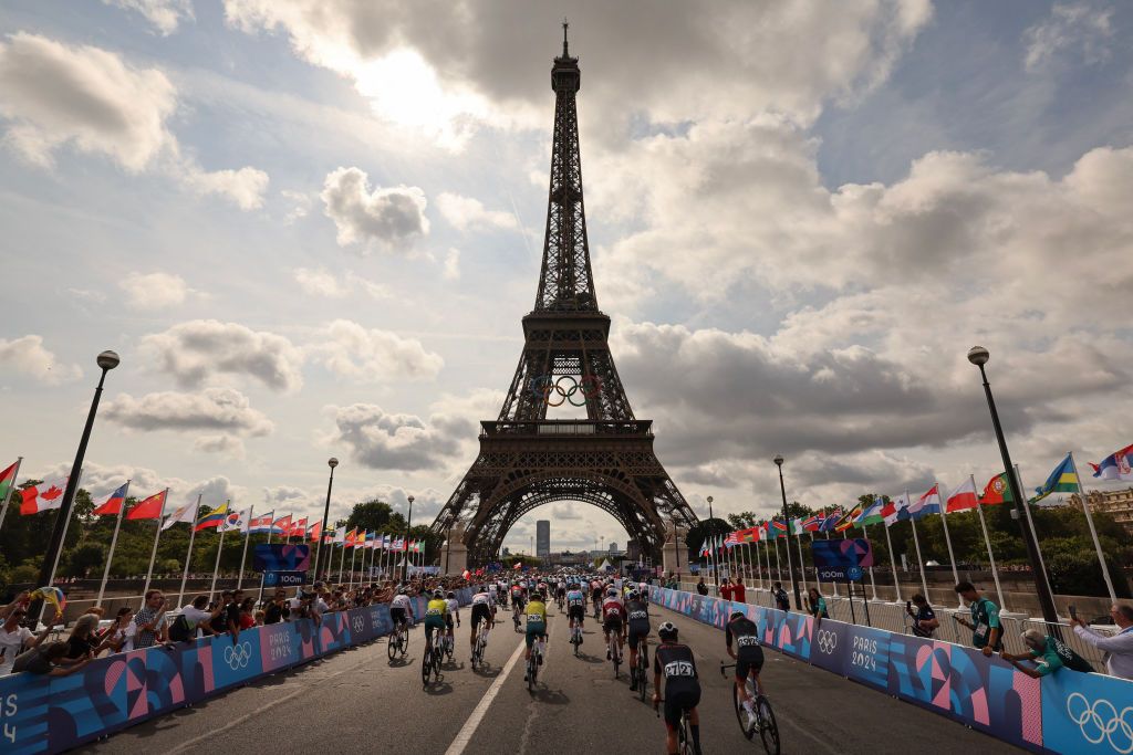 Riders pass under the Eiffel Tower at the start of the Olympic Men's Road Roace