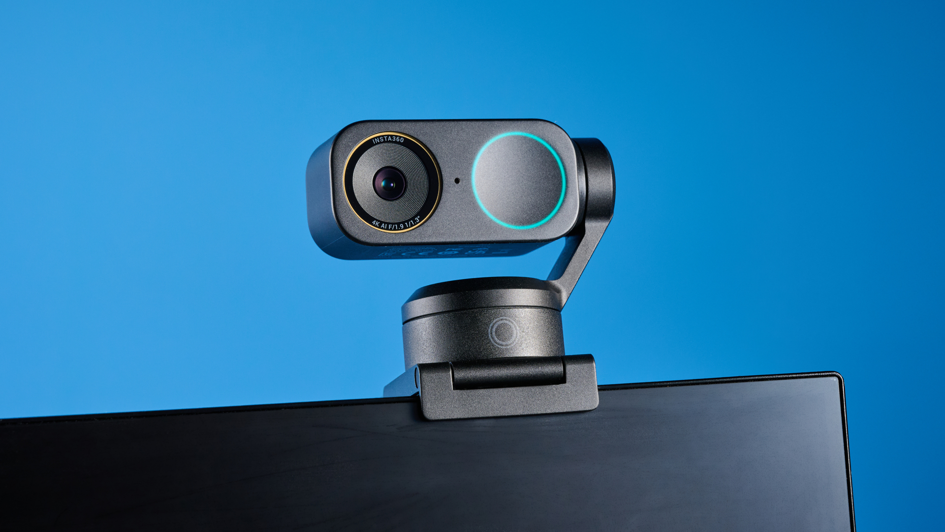 Insta360 Link 2 Pro in graphite black attached to a computer screen photographed on a blue background