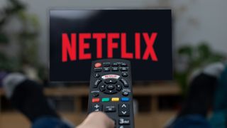 Netflix logo on a TV screen with a remote pointing at it
