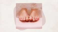 a woman's feet emerging from bubblu water in a pink foot bath