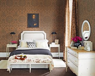 A bedroom furniture idea with brown wallpapered walls and white traditional furniture