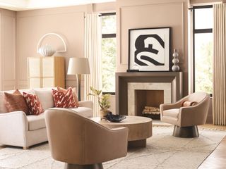 A pale pink monochromatic living room with a fireplace