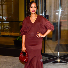 Kerry Washington wearing a deep side part hairstyle and burgundy lipstick that matches her sweater.