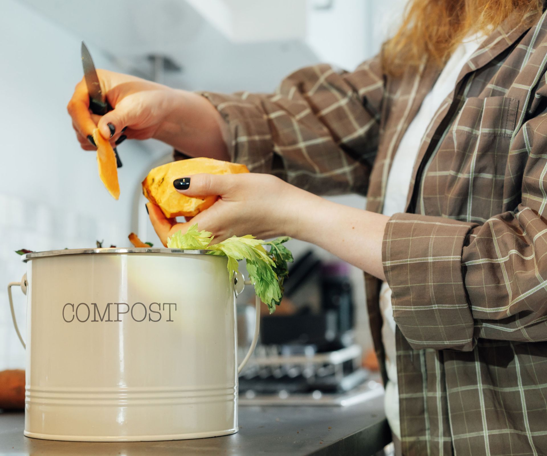 adding food scraps to kitchen counter compost bin