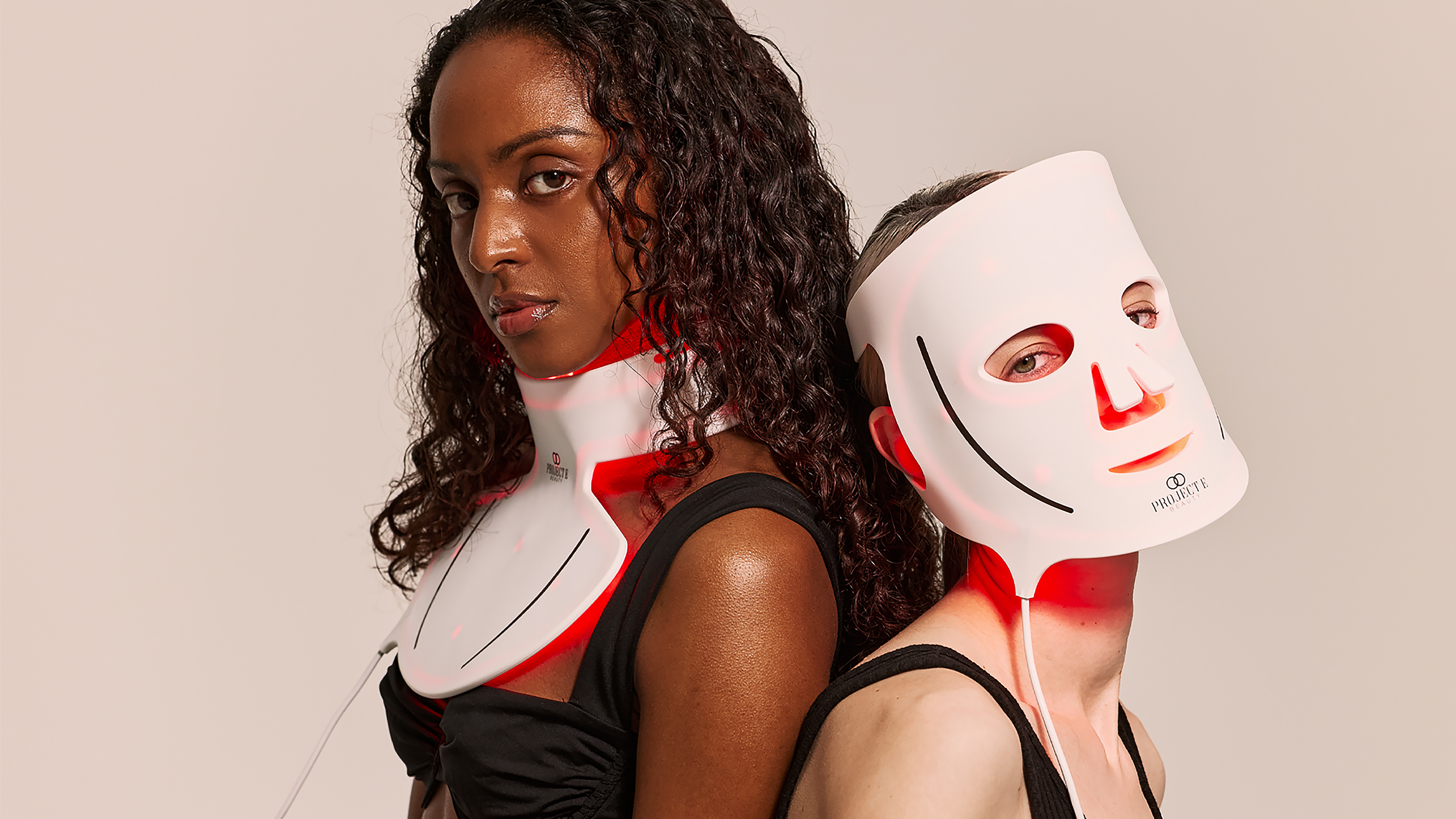 Two women wearing Project E Beauty&#039;s LED masks, one wearing the face mask and one wearing the neck mask