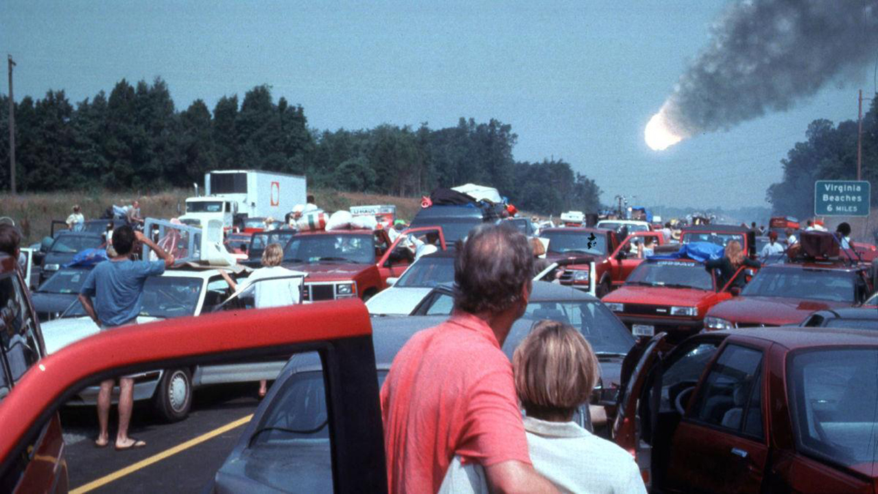 People get out of their cars on a busy highway to watch an fiery ball slam into Earth in this still from the movie Deep Impact