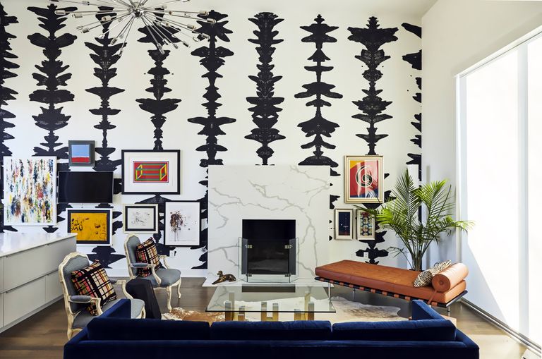 living room wall covered in black and white graphic print wallpaper with a white fireplace