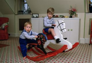 Prince William And Prince Harry Playing On A Rocking Horse In Their Playroom At Kensington Palace