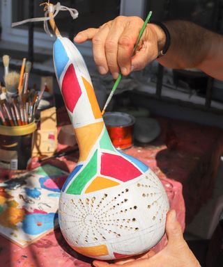 Painting a dried ornamental gourd