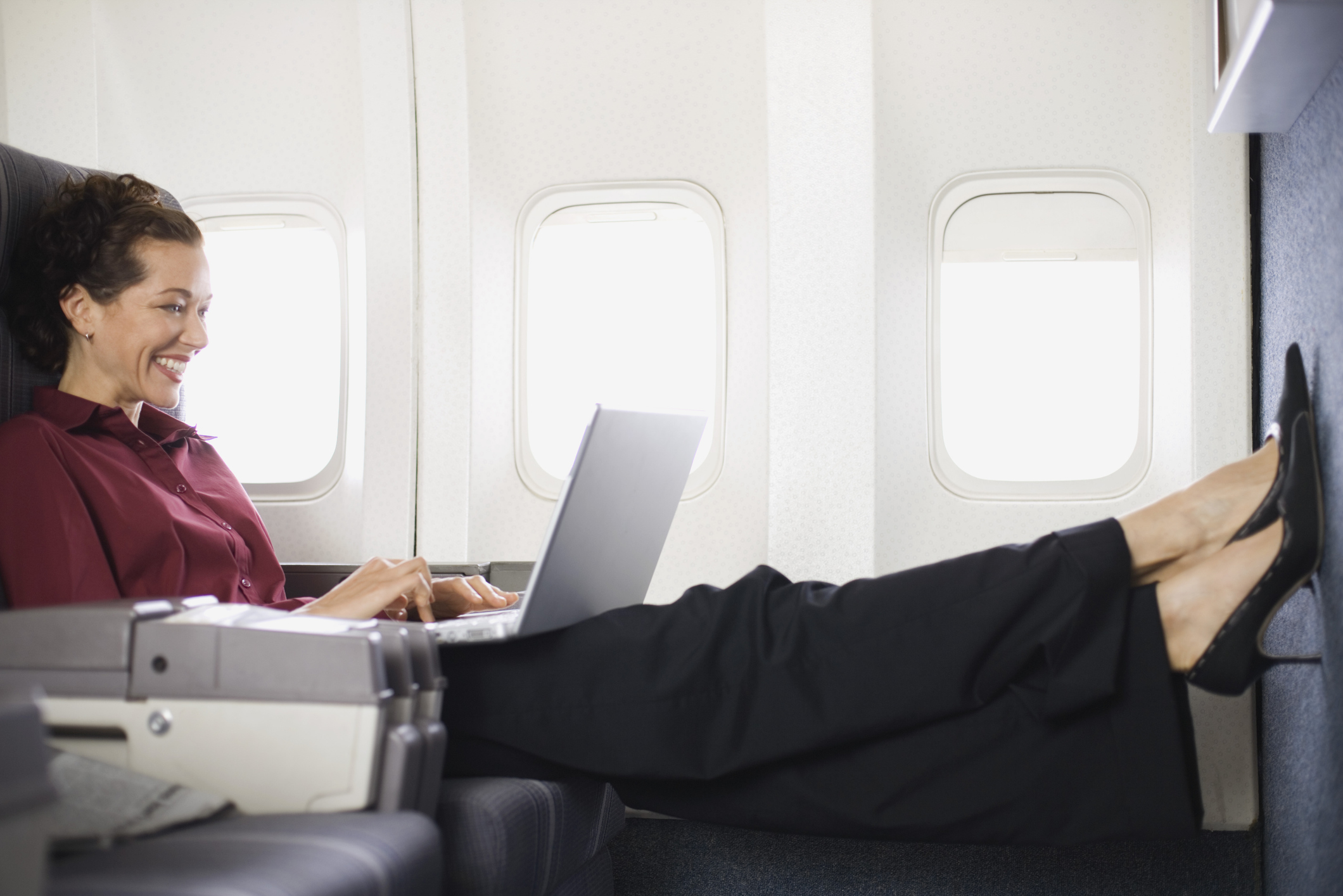 A woman sits on an airplane.