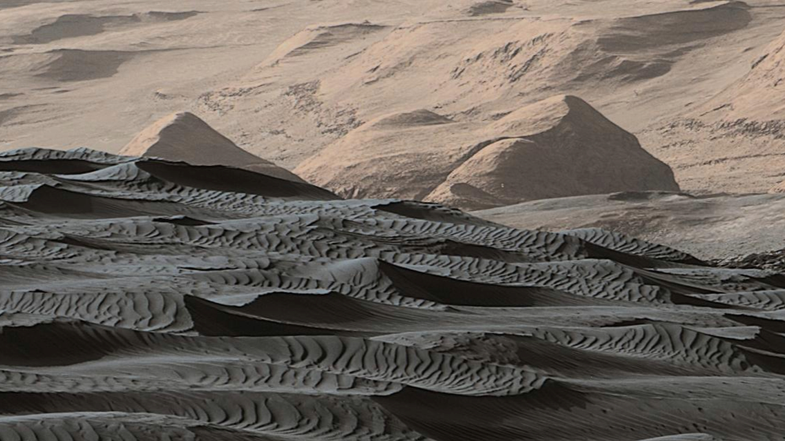 A series of reddish sand dunes