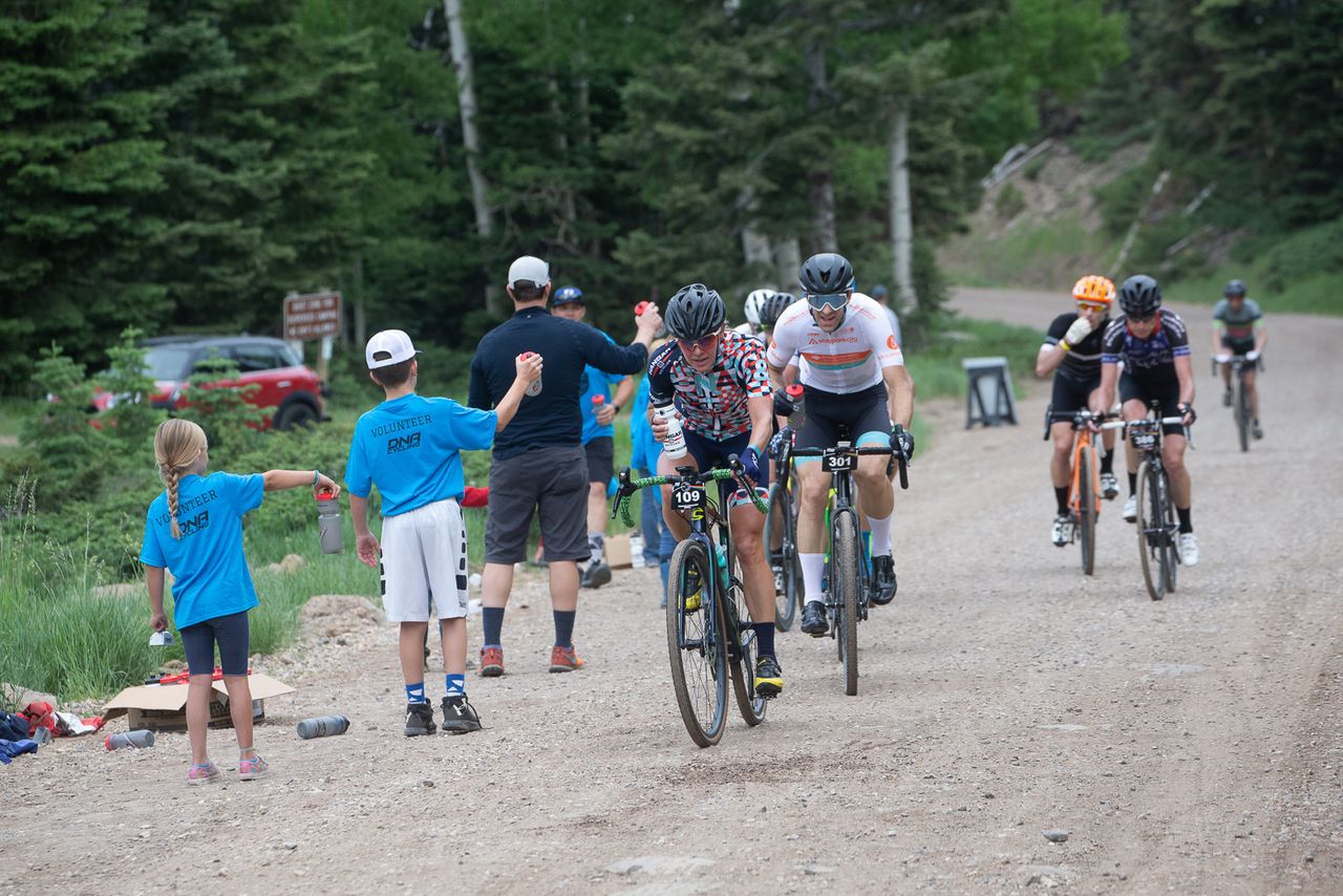 Amy Charity (DNA Pro Cycling) grabs a bottle at one of the 4 well supplied Aid Stations.