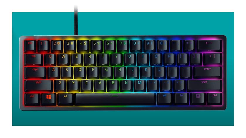 The Razer Huntsman Mini 60% gaming keyboard floats in the teal PC Gamer deal void. The per-key RGB lights are on.