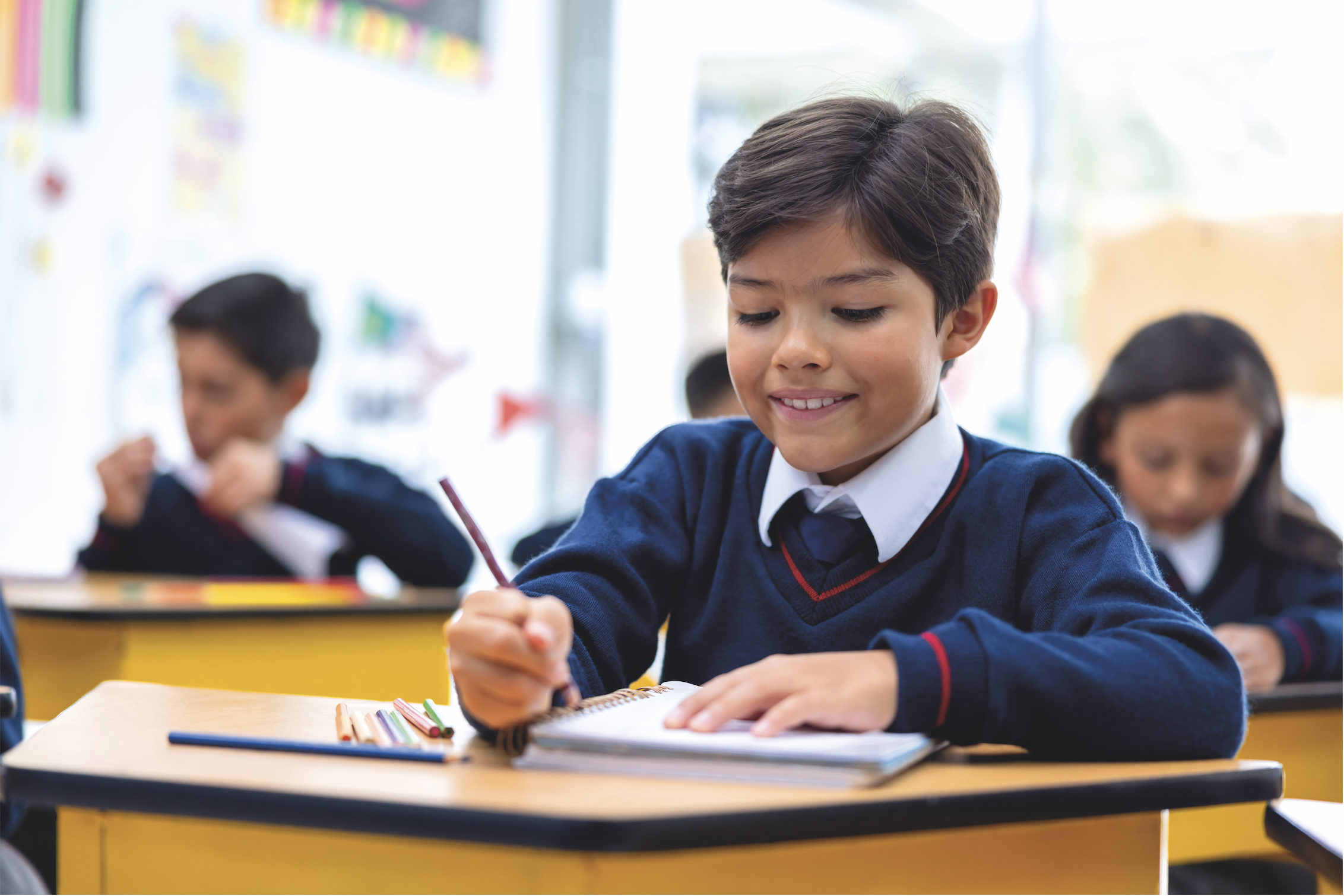 schoolboy writing with pencil