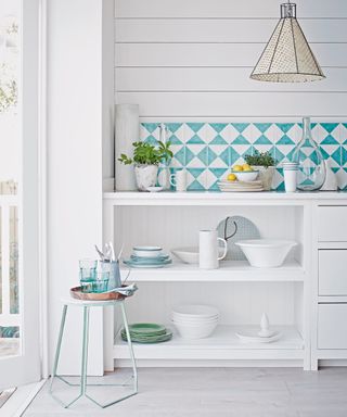 An all white kitchen with kitchen wall tile ideas in white and pale blue.