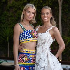 Kitty Spencer wearing a bright crop top and skirt posing with Eliza Spencer in a white floral dress