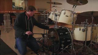 Engineer, Darrell Thorp positions microphone on bass drum