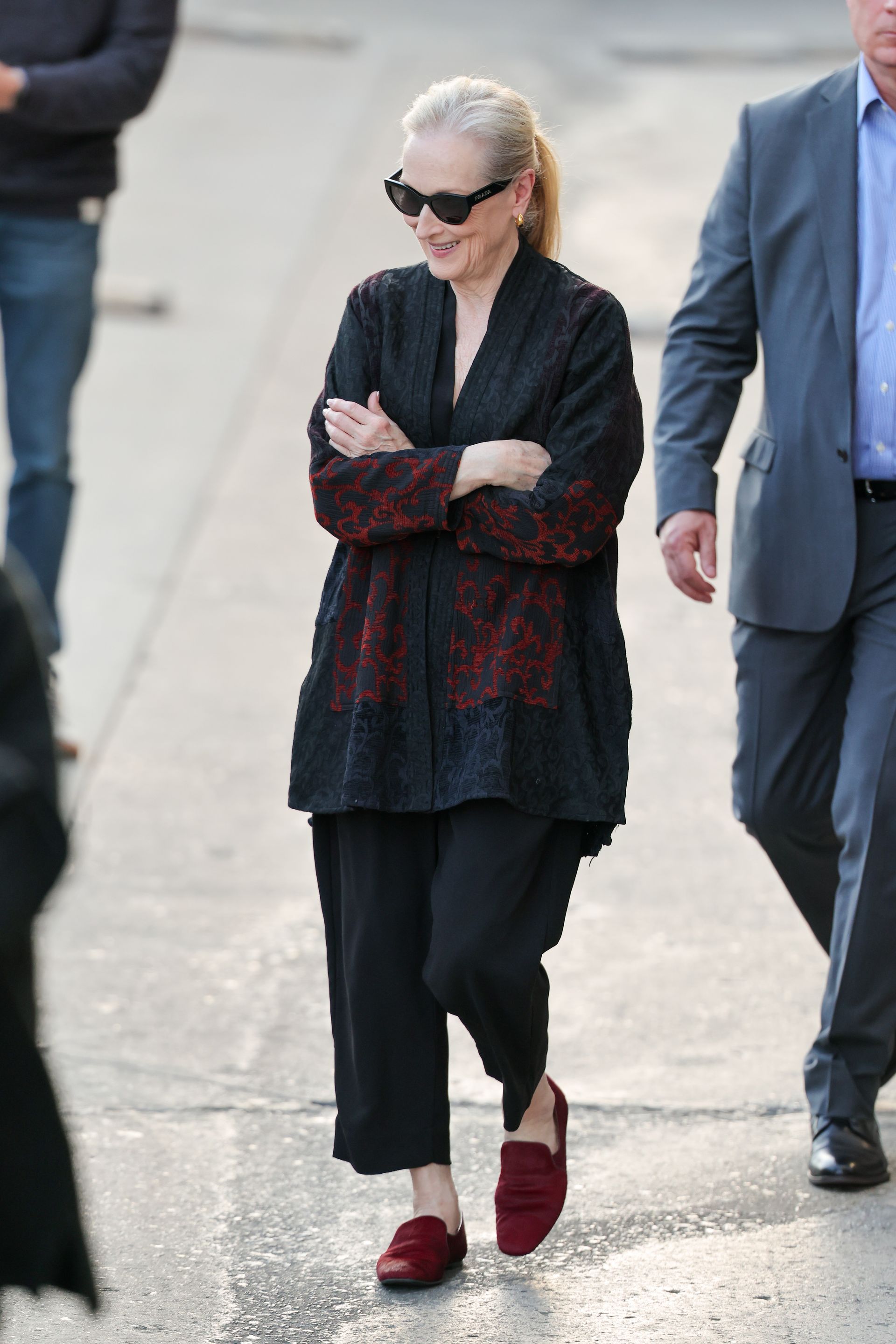 Meryl Streep wears cropped trousers with burgundy loafers and a black embroidered jacket.