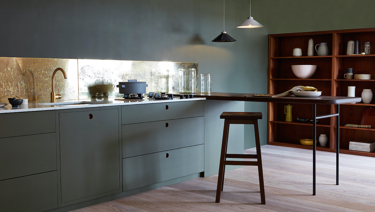 kitchen with dark cabinets and brass splashback