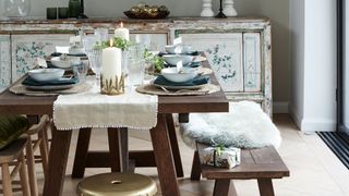 Christmas dining room with rustic decor and neutral table runner under a garland as a simple Christmas centrepiece idea