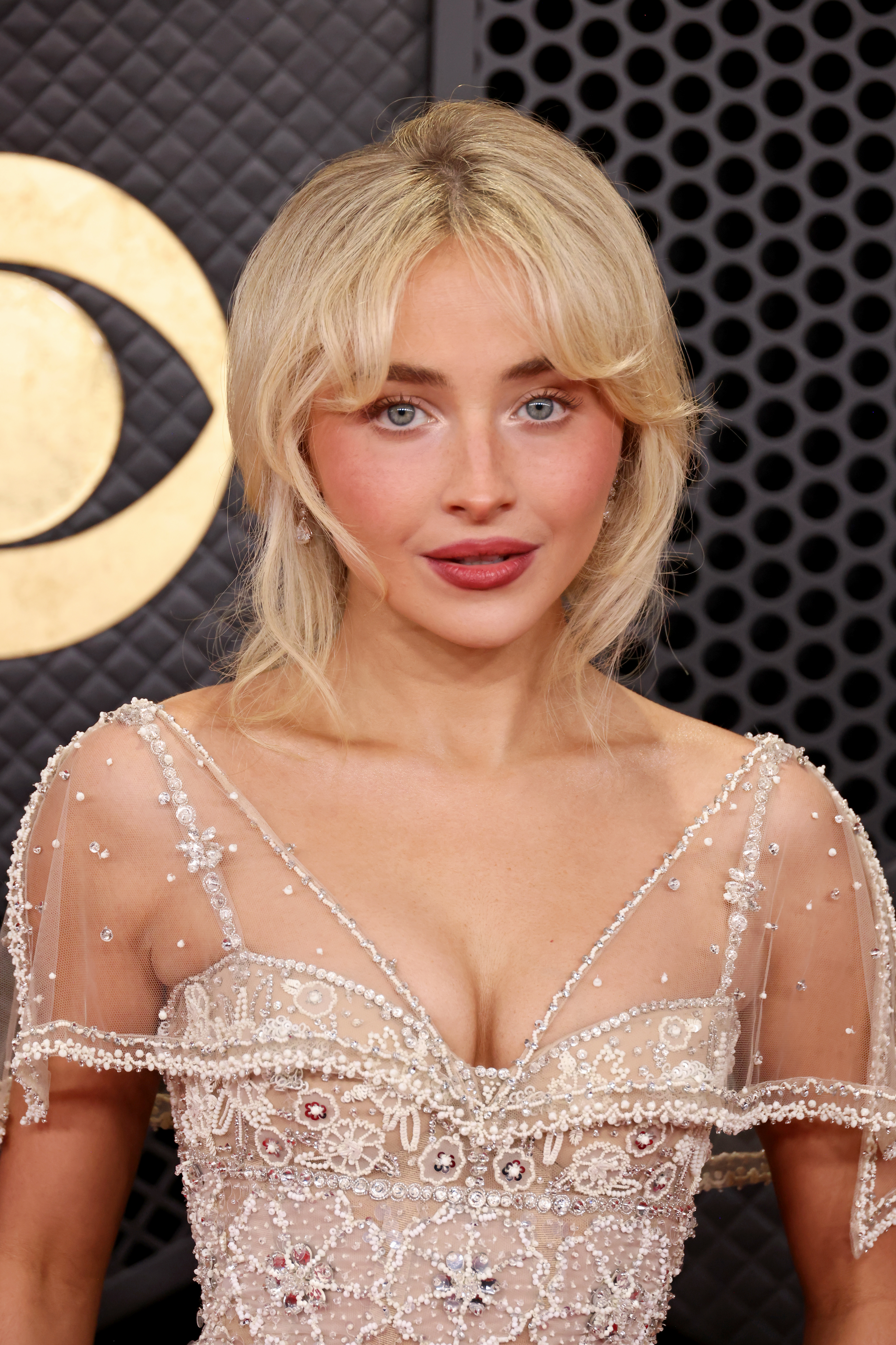 a blonde woman poses for a photo at the grammys