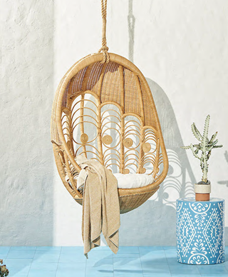 boho hanging chair and blue floor and white walls